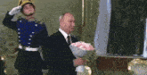 a man in a suit and tie is holding a bouquet of pink roses