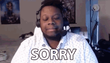a man wearing headphones and a white shirt is making a sorry sign .