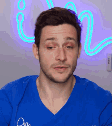 a man wearing a blue scrub top with the word dr on it