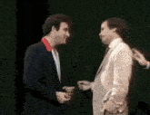 two men in suits are standing next to each other and talking