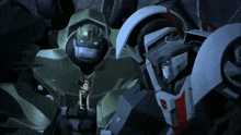 a girl is standing between two transformers one of which has a red stripe on its chest