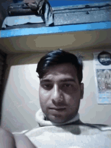 a man taking a selfie in front of a wall that has a calendar on it that says ' a ' on it