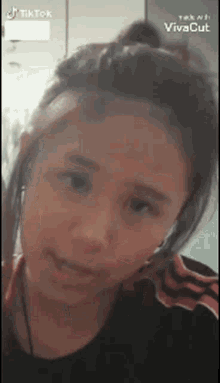 a young girl is wearing headphones and making a funny face while looking at the camera .