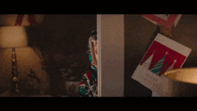 santa claus stands in front of a christmas tree