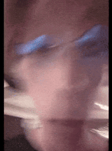 a blurry picture of a person 's face with a blue light behind them