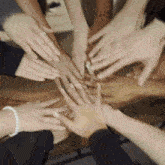 a group of people are putting their hands together in a circle