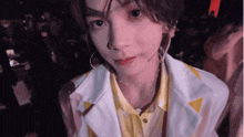 a close up of a person 's face with a white jacket and yellow shirt