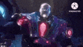 a man is standing in the dark with a pink light coming out of his hand .