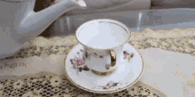 a cup of tea is sitting on a saucer next to a teapot .
