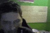 a blurry picture of a man 's face in a room with a green wall