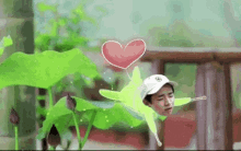 a man is standing next to a flower with a heart shaped balloon .