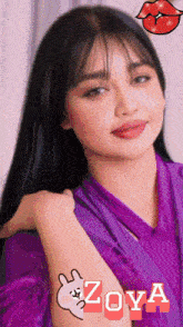 a woman wearing a purple shirt with the name zoya on her arm