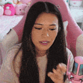 a woman sitting in a pink chair with a hello kitty on the back