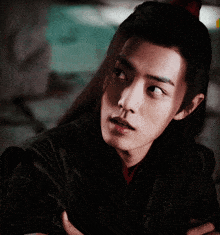 a close up of a man 's face with long black hair