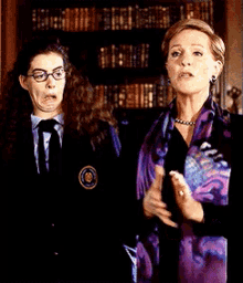 a woman wearing a purple scarf stands next to another woman