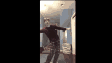 a man is dancing in a room with a welcome sign on the wall .