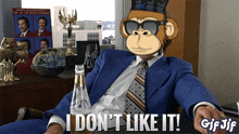 a gif of a man in a blue suit and tie with a monkey on his head saying i don 't like it