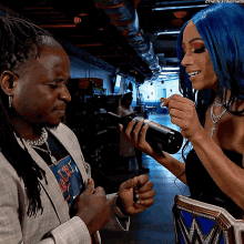 a woman with blue hair is holding a bottle next to a man