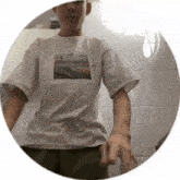 a man wearing a white t-shirt with a picture of a city on it