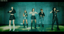 a group of young women are dancing in front of a wall .