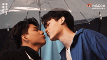 two men kissing under a clear umbrella with a weibo logo in the corner