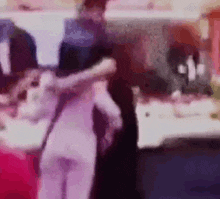 a blurry picture of a couple dancing in a kitchen .