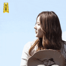 a woman stands in front of a yellow caution sign that says kyunk