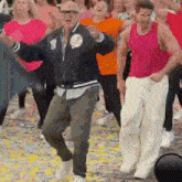 a group of people are dancing in a room with confetti .
