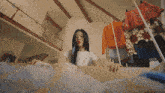 a woman in a white shirt is looking at clothes