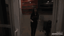a woman standing in a dark room with the words made in animotica on the bottom right