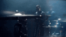 a man playing a drum set in the dark