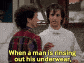 two men are standing next to each other and one of them says when a man is rinsing out his underwear .