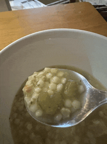 a close up of a bowl of soup with a plastic spoon in it
