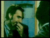 a man in a suit is talking on a phone