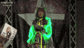 a woman in a neon green outfit stands in front of a stardom banner