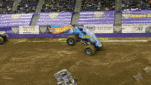 a monster truck is jumping over another monster truck in front of a fox advertisement