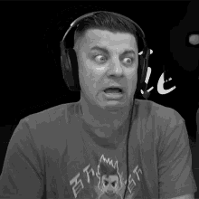 a man wearing headphones and a t-shirt that says thrasher makes a surprised face