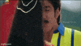 a man in a yellow shirt kisses a woman on the cheek .