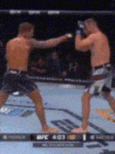 two men are fighting in a boxing ring with a scoreboard that says ufc 400