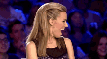 a woman with a microphone in her mouth is laughing