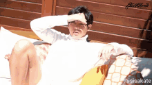 a man in a white sweater is laying on a couch with his hand on his forehead and the words thisisakate below him