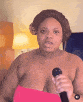 a woman is holding a microphone in front of her chest and wearing a hat .