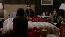 a man with a bandage on his eye is sitting on a bed with two other people