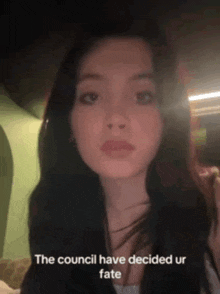 a woman with long dark hair is looking at the camera with the words " the council have decided ur fate " above her