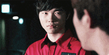 a man in a red shirt with the letter t on the front
