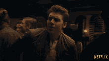 a man in a crowded room with a netflix logo on the bottom