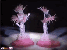 two dolls are dancing in front of a screen that says " vcrparis live "