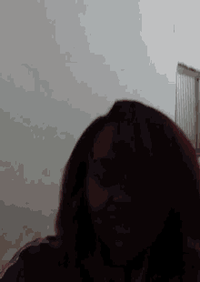 a woman with red hair is making a funny face in front of a white wall