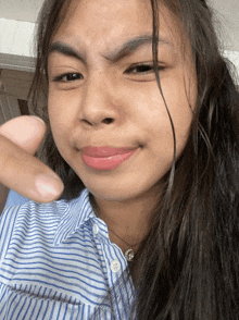a woman in a striped shirt is making a funny face