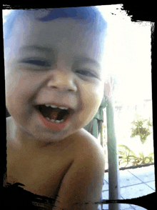 a baby is laughing with his mouth wide open